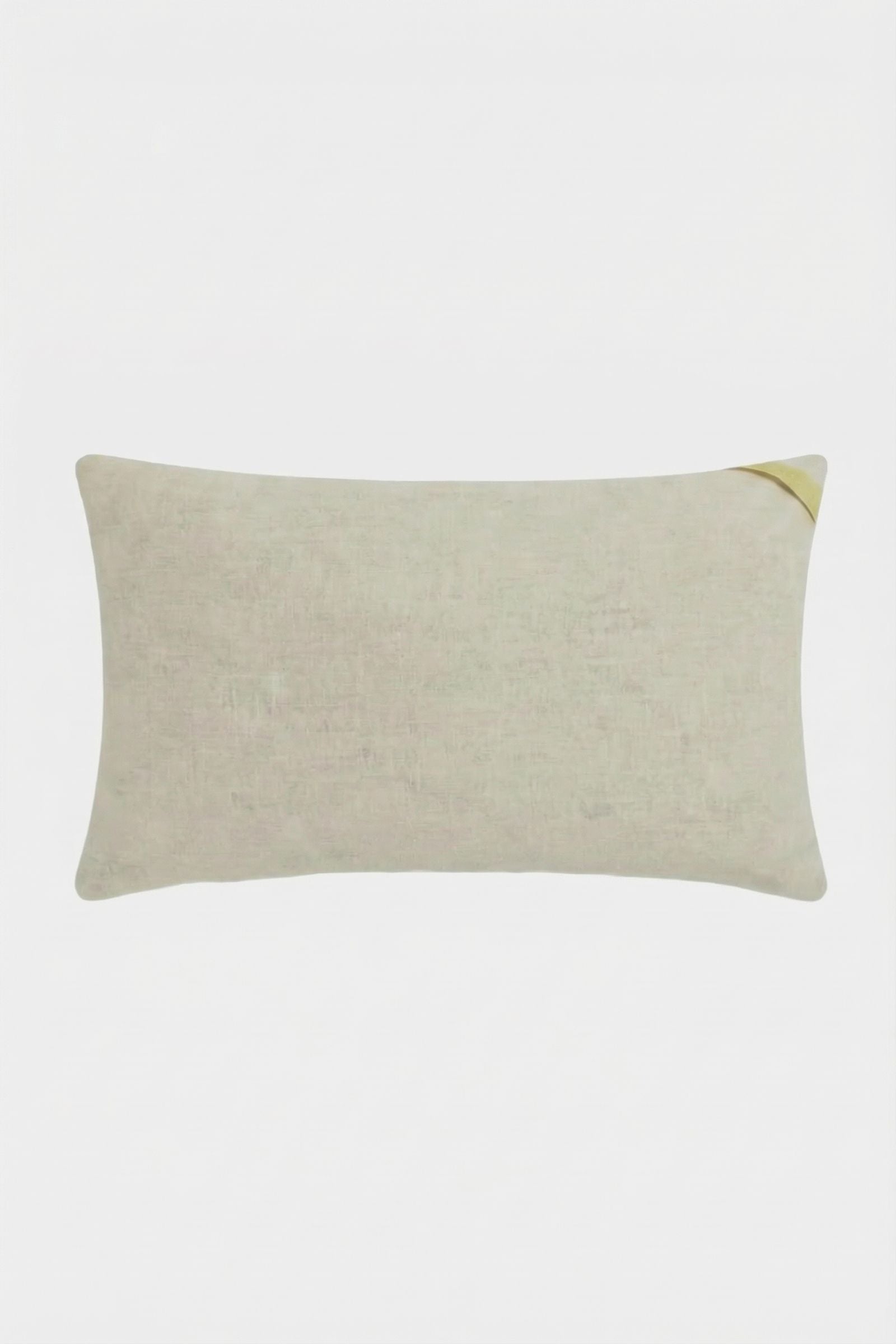 The Roseville Embroidered Lumbar Pillow is rectangular and light beige with a subtle texture and a small golden accent on the top right corner, displayed against a plain white background.