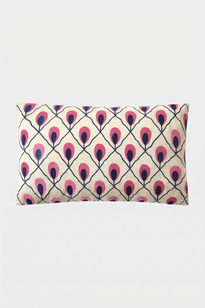The Roseville Embroidered Lumbar Pillow features a cream background with a geometric pattern of stylized pink and dark blue peacock feathers.