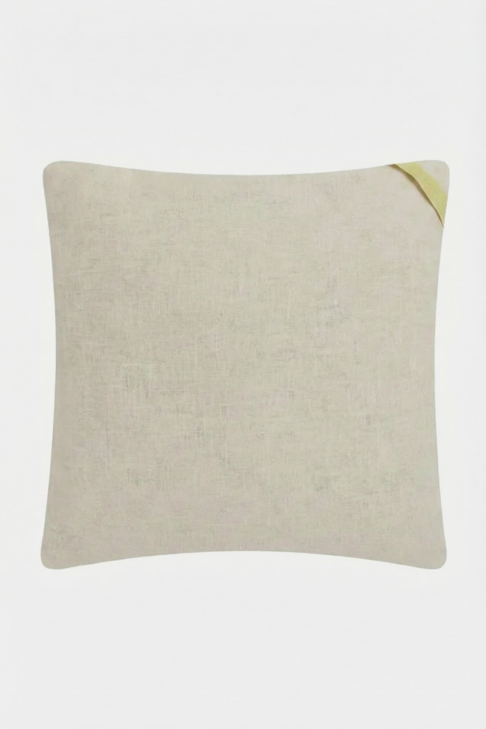 The Shante Embroidered Pillow is a rectangular beige cushion featuring subtly textured fabric and a small yellow fabric tag on the top right corner, showcased against a plain white background.