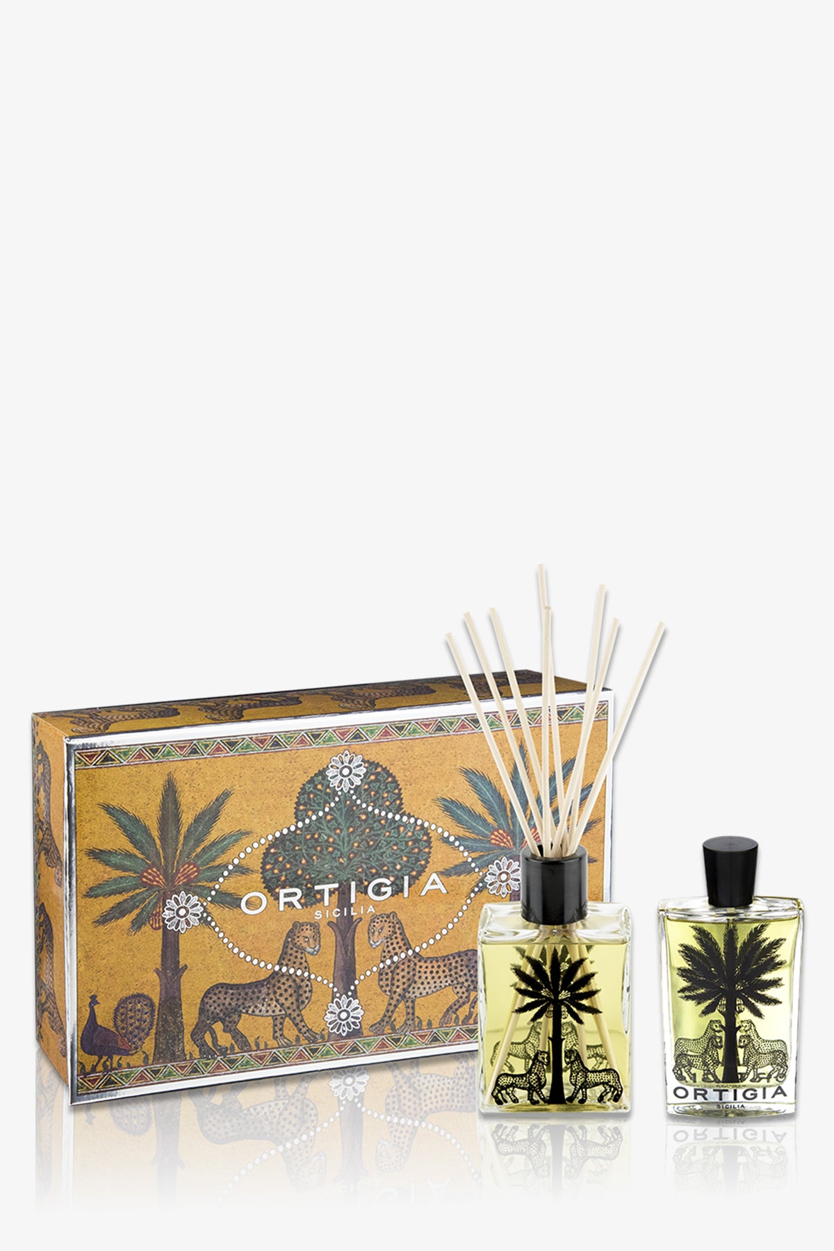The Ortigia Casa Set includes a yellow patterned box, a glass diffuser bottle with reeds, and a matching perfume bottle, all decorated with black palm tree and animal motifs.