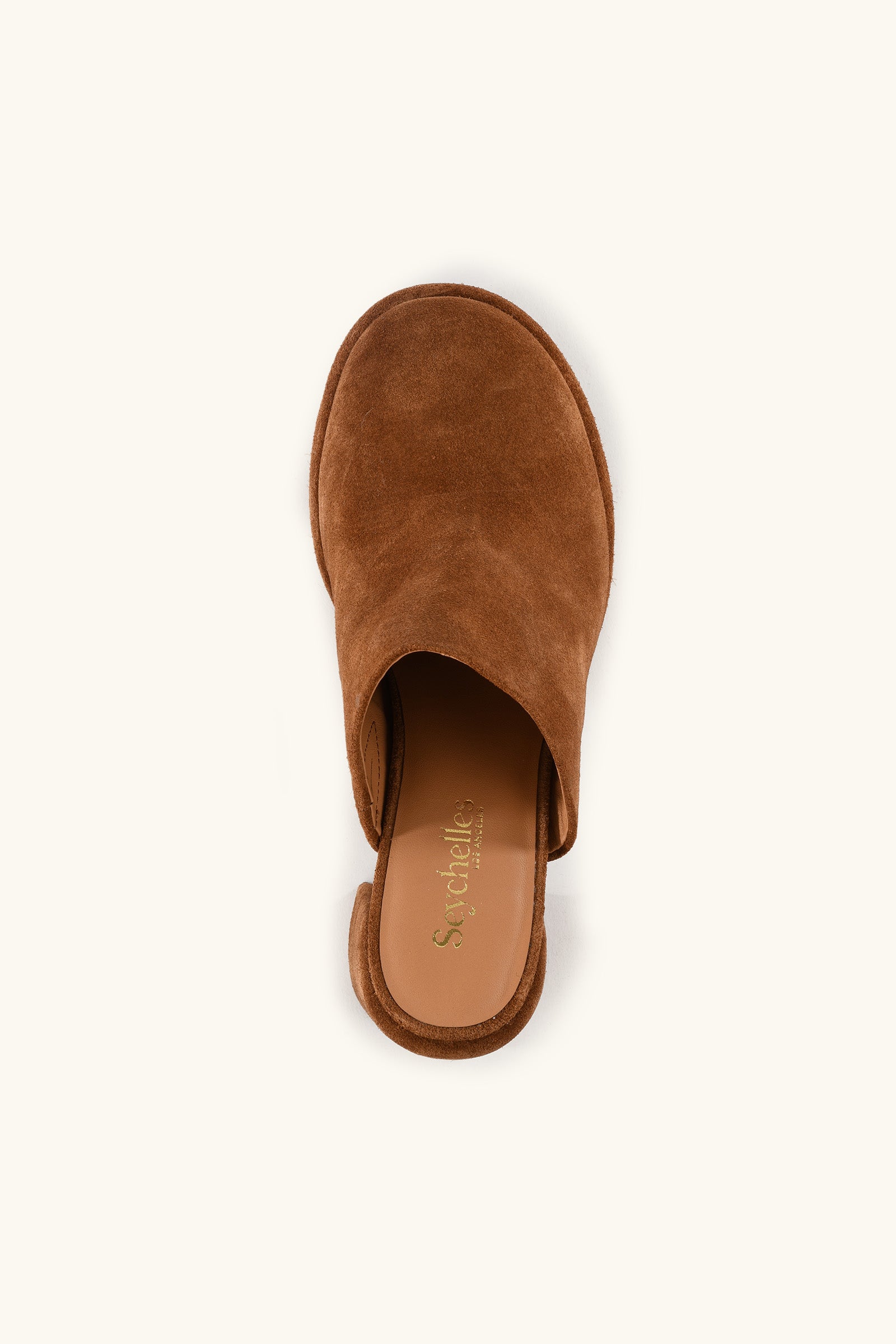 A top view of the Honor Mule - Brown Suede, a slip-on mule with an open back and tan insole featuring the Seychelles brand logo, shown against a light beige background.