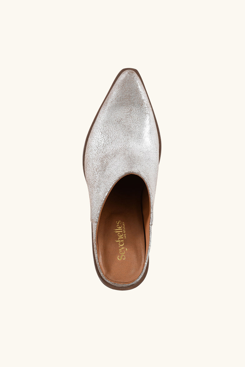 Top view of a single Seychelles Morning Joe Mule in silver, featuring a pointed toe, slip-on design, brown insole, and Seychelles brand name in gold lettering inside.