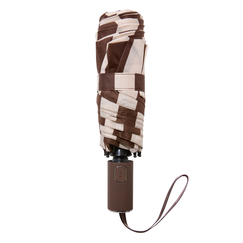 The FABFITFUN UMBRELLA is a closed, compact umbrella with a geometric brown and beige pattern, featuring a dark brown handle and a wrist strap, set against a plain white background.