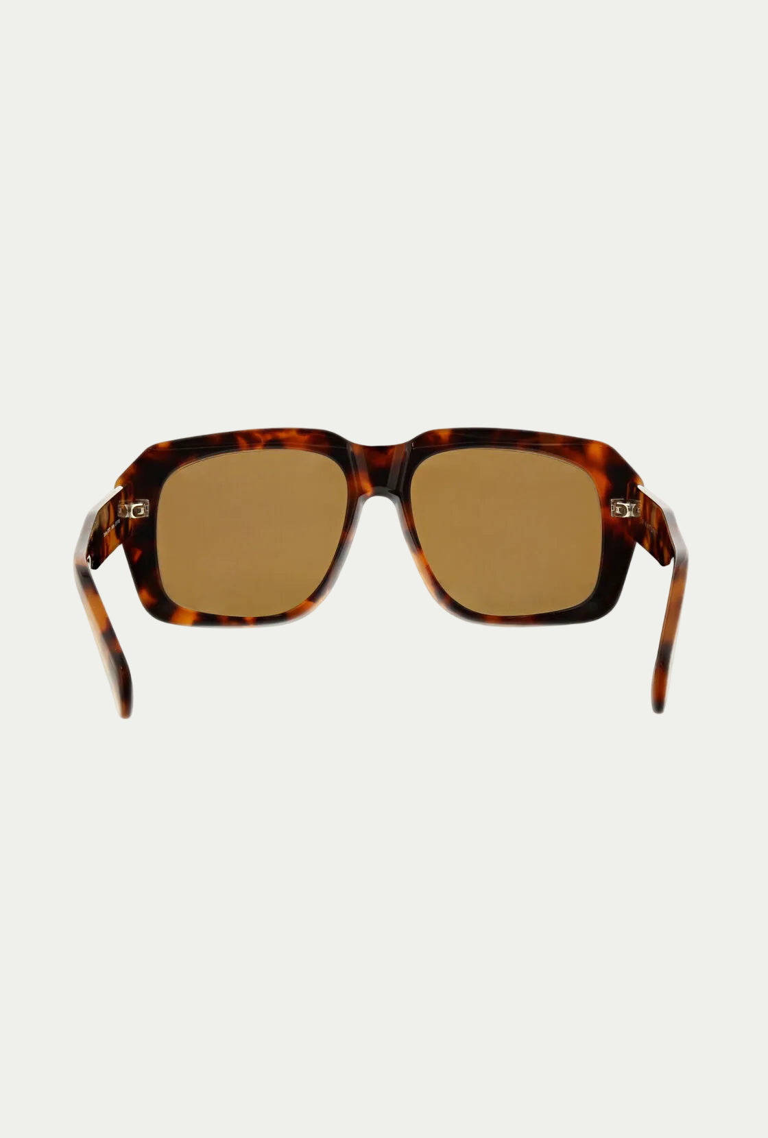 Andros Sunglass: Bold rectangular tortoiseshell acetate frames with brown-tinted lenses, providing 100% UVA/UVB protection. Shown front-facing on a white background. Includes a signature Trina Turk sunglass case.